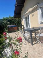 eine Terrasse mit einem Tisch, Stühlen und Blumen in der Unterkunft Maison Time Break Jacuzzi - 4 étoiles in Thonon-les-Bains