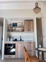 a kitchen with a stove and a table with a chair at Casa Mariuccia in Algajola