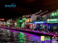 Eine Stadt leuchtete nachts neben einem Fluss in der Unterkunft Wayfarer Guest House Jonker Street Melaka By Heystay Management in Malakka