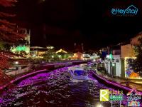 ein Boot, das nachts den Fluss hinunter fährt in der Unterkunft Wayfarer Guest House Jonker Street Melaka By Heystay Management in Malakka