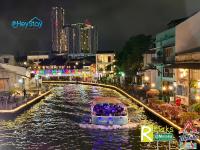 ein Boot auf einem Fluss in einer Stadt nachts in der Unterkunft Wayfarer Guest House Jonker Street Melaka By Heystay Management in Malakka