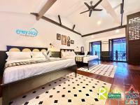 ein Schlafzimmer mit zwei Betten und einem Deckenventilator in der Unterkunft Wayfarer Guest House Jonker Street Melaka By Heystay Management in Malakka