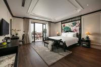 Un dormitorio con una cama grande con un cuadro en la pared. en Amira Hotel Hanoi, en Hanói