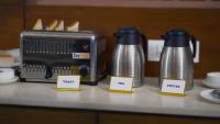 a counter with two water bottles next to a toaster at Sai Maa Hotel & Residency in Puttaparthi