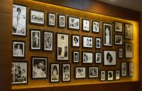 a wall filled with pictures of people at Sai Maa Hotel & Residency in Puttaparthi