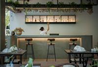 暹粒Eightfold Urban Resort的站在餐厅酒吧的女人