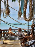 a man and a woman sitting at a table on the beach at Haadson Resort & Koh Raham in Haad Son
