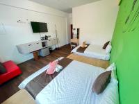 a living room with two beds and a television at Rihchun Homestay in Hengchun South Gate