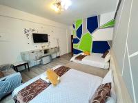 a small room with two beds and a tv at Rihchun Homestay in Hengchun South Gate