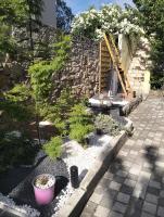 a garden with a stone wall and a plant at Logement zen love, 5 mn de la plage in Toulon