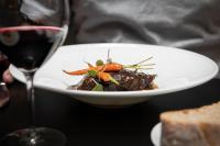 un plato de comida junto a una copa de vino en Hotel Plaza, en A Coruña