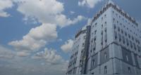 un edificio alto y blanco con nubes en el cielo en Rawaz Hotel &amp; Motel, en As Sulaymānīyah
