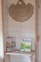 a shelf in a wall with a wicker hat and books at Dihan Evasion in Ploemel