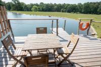 a wooden table and chairs on a deck next to a lake at Dihan Evasion in Ploemel