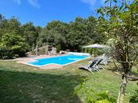 a pool in a yard with chairs and an umbrella at Les gîtes de La Pellerie - 2 piscines &amp; spa Jacuzzi - Touraine - 3 gîtes - familial, calme, campagne in Saint-Branchs