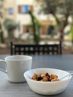 a bowl of granola and two cups on a table at Résidence CATALINA in Saint-Florent