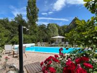 a swimming pool in a garden with red roses at Les gîtes de La Pellerie - 2 piscines &amp; spa Jacuzzi - Touraine - 3 gîtes - familial, calme, campagne in Saint-Branchs