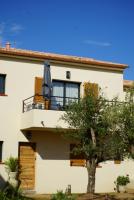 a building with a balcony with an umbrella on it at Résidence CATALINA in Saint-Florent