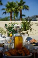 a table with a plate of food and a bottle of oil at Résidence CATALINA in Saint-Florent