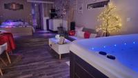 a living room with a tub with a christmas tree at Chambres d&#39;hôtes avec jacuzzi privatif in Westrehem