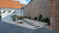 a courtyard in front of a building with a brick wall at Chambres d&#39;hôtes avec jacuzzi privatif in Westrehem
