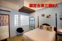 a bedroom with a white bed and a black chair at Locking B&amp;B台東民宿 in Taitung City