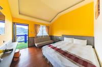 a bedroom with yellow walls and a bed with a desk at Julie&#39;s Garden, Cingjing - Fon Chin Homestay in Ren&#39;ai
