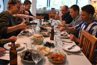 un grupo de hombres sentados alrededor de una mesa comiendo comida en Quinta Ecológica da Peneda Agroturismo by Peneda ecofarm, en Arcos de Valdevez
