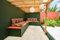 a pergola with a couch on a patio at Villa spacieuse proche de la mer avec piscine privée et vue - BED AND COFFEE DIAMOND in Le Diamant