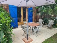 a table and chairs and an umbrella on a patio at Gîte le Chai in Le Teich