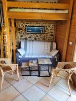 a room with a couch and two chairs and a table at Gîte le Chai in Le Teich