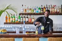 un homme debout à un bar en train de préparer une boisson dans l'établissement Grand Isle Resort & Residences, à Farmerʼs Hill