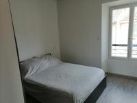 a bed in a white room with a window at Appartement provence verte in Forcalqueiret