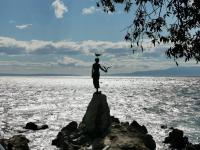 a statue of a person standing on a rock in the water at Romeo&amp;Juliet in Opatija