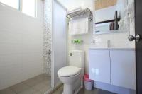 a white bathroom with a toilet and a sink at Shanghai Time in Hualien City