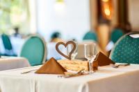 Una mesa con un mantel blanco y una servilleta con forma de corazón. en Hotelpark der Westerwald Treff, en Oberlahr