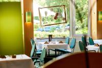 Un comedor con mesas y sillas y una ventana. en Hotelpark der Westerwald Treff, en Oberlahr