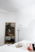 a bedroom with a painting on the wall next to a bed at Au Petit Thouars in Thouars