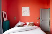 a bedroom with red walls and a bed with pillows at Au Petit Thouars in Thouars