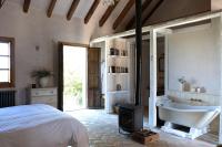 a bedroom with a bed and a bath tub and a stove at Casa La Siesta in Vejer de la Frontera