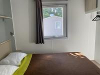 a bedroom with a bed and a window at Mobil-home (Clim, Tv)- Camping Narbonne-Plage 4* - 022 in Narbonne-Plage