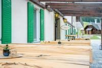 a row of wooden tables on a street with green shutters at Lorettohof Hotel Garni in Gaal