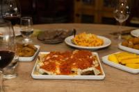 ein Tisch mit Tellern mit Essen und Gläsern Wein in der Unterkunft Pousada e Restaurante Del Miro in Nova Pádua