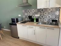 a kitchen with white cabinets and a sink at Amaryllis aux Bords de Loire in Les Rosiers