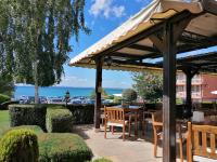 een houten paviljoen met tafels en stoelen en de oceaan bij Family Hotel Berlin Beach Sveti Vlas in Sveti Vlas