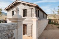 a white house with a brick wall and a fence at Château de Pierreclos in Pierreclos