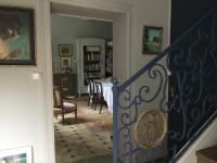 a staircase leading to a living room and a dining room at L’orangerie du Général in Saint-Jean-dʼAngély