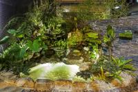 a garden with a waterfall in a brick wall at Citizen Hotel in Taipei