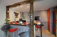 a kitchen with red stools and a counter top at La porcherie du pet en l&#39;air in Saint Malo