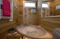 a bathroom with a tub with a window and a mirror at La porcherie du pet en l&#39;air in Saint Malo